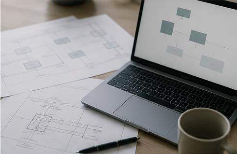 Laptop og tekniske netværksdiagrammer på et skrivebord